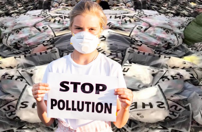 Une jeune fille portant un masque de protection tient une pancarte avec l'inscription STOP POLLUTION à devant un amas de vêtements jetés, symbolisant la lutte contre la pollution causée par l'industrie de la mode.