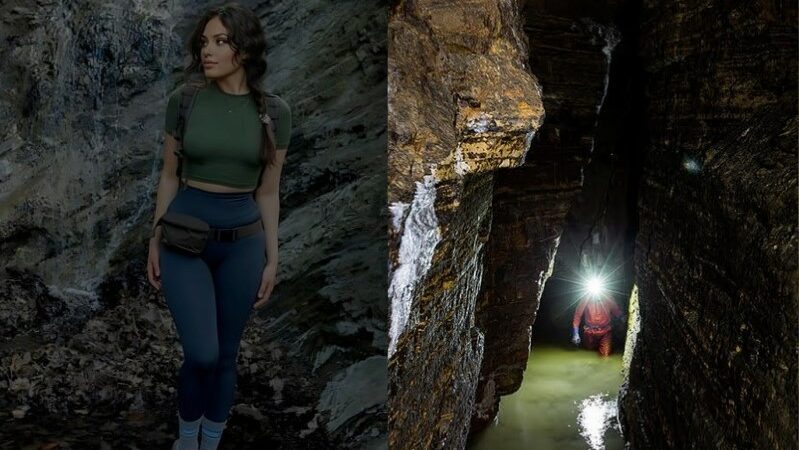 Femme en tenue de randonnee devant une paroi rocheuse a cote d'un speleologue explorant une grotte etroite et sombre avec une lampe frontale.