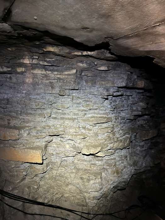 Paroi rocheuse stratifiee a l'interieur d'une grotte a Montreal avec des textures mises en lumiere.